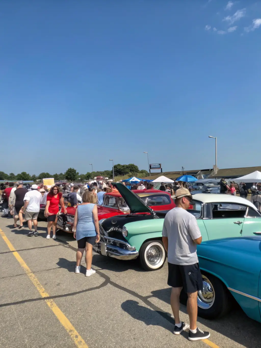 A group of TACOT CLUB GAVOT members enthusiastically preparing their vintage cars for an upcoming rally, showcasing the camaraderie and excitement of the event.