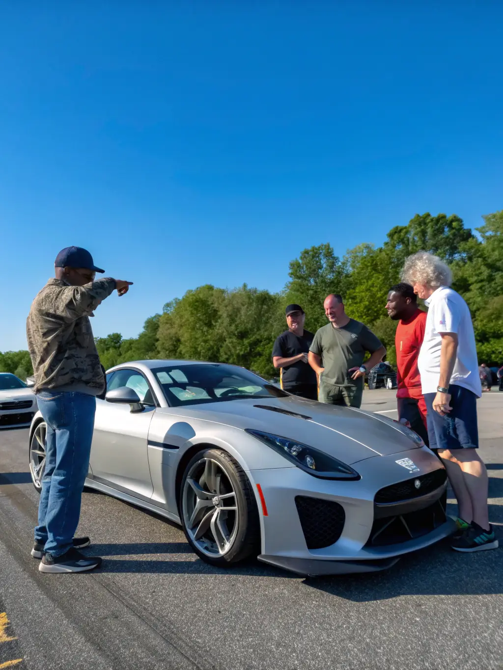 A candid shot of TACOT CLUB GAVOT members gathered at a club meeting, sharing stories and experiences related to vintage car restoration and preservation, fostering a sense of community.